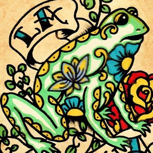 K&ouml;nnte beinhalten: Ein gr&uuml;ner Frosch mit gelben und blauen Blumenmustern, der auf einem braunen Hintergrund mit einem Banner sitzt, auf dem "LX" steht.