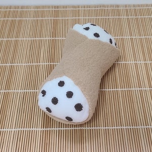 Juguete para perros pequeños con forma de cannoli que emite un chirrido.