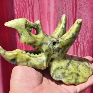 Teschio di triceratopo in cristallo di giada verde: scultura metafisica di dinosauro