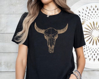 Puede incluir: Una camiseta negra con un gráfico marrón de un cráneo de toro en la parte delantera.