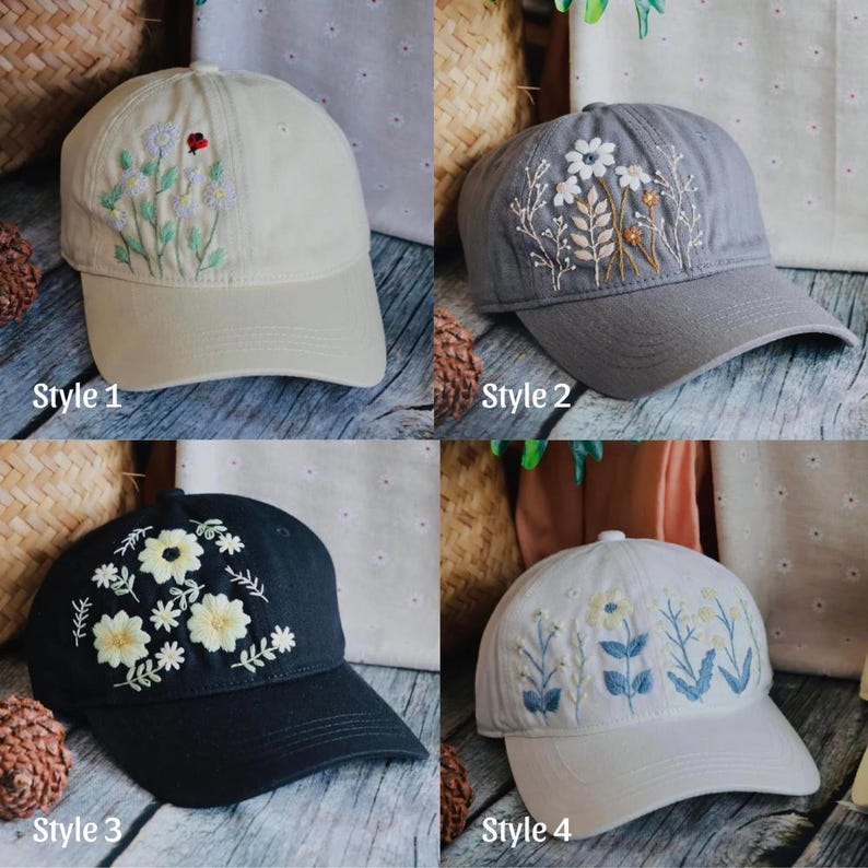 May include: Four baseball caps with floral embroidery. Styles include a beige cap with white and red flowers, a gray cap with white and brown flowers, a black cap with yellow flowers, and a white cap with blue and yellow flowers. Each cap has the style number printed on it.
