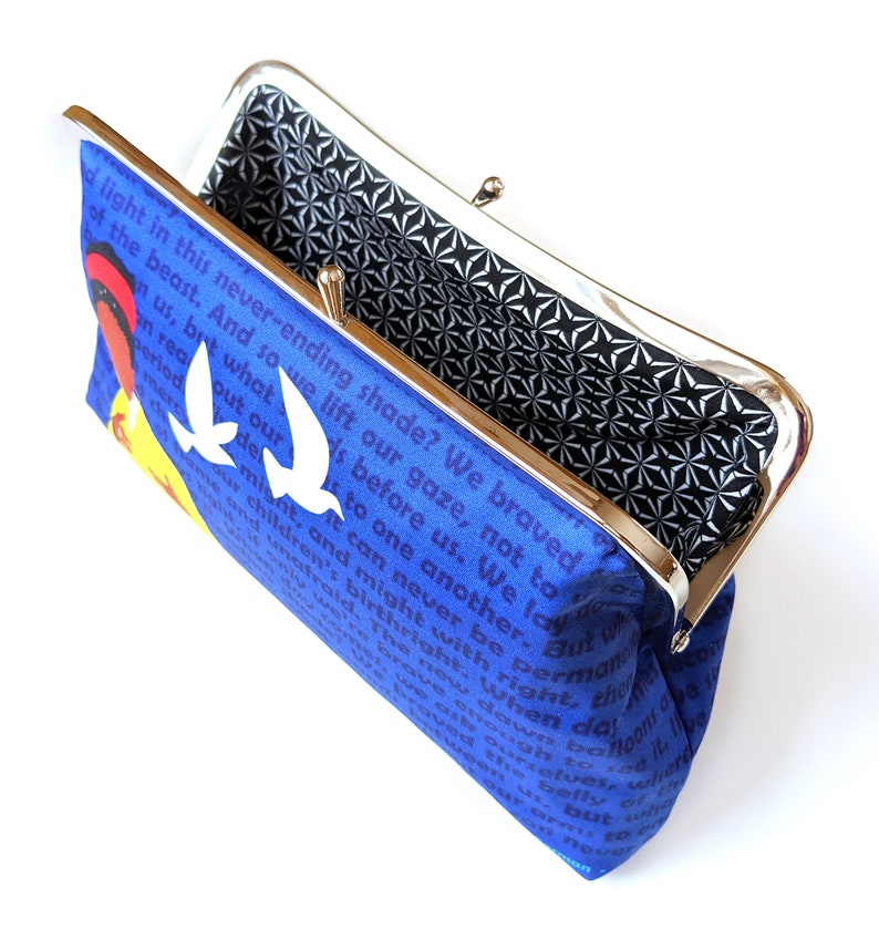 The clutch is open and shown from above. Inside, the lining is black with a white design.