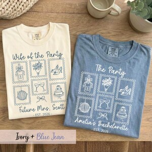 May include: Two t-shirts, ivory and blue jean, with white graphic designs. The ivory shirt says "Wife of the Party" and "Future Mrs. Scott - EST. 2026-". The blue jean shirt says "The Party" and "Amelia's Bachelorette - EST. 2026-".