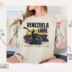 May include: A beige sweatshirt with a graphic print of a Venezuelan flag and the text "Venezuela Libre hasta el final".
