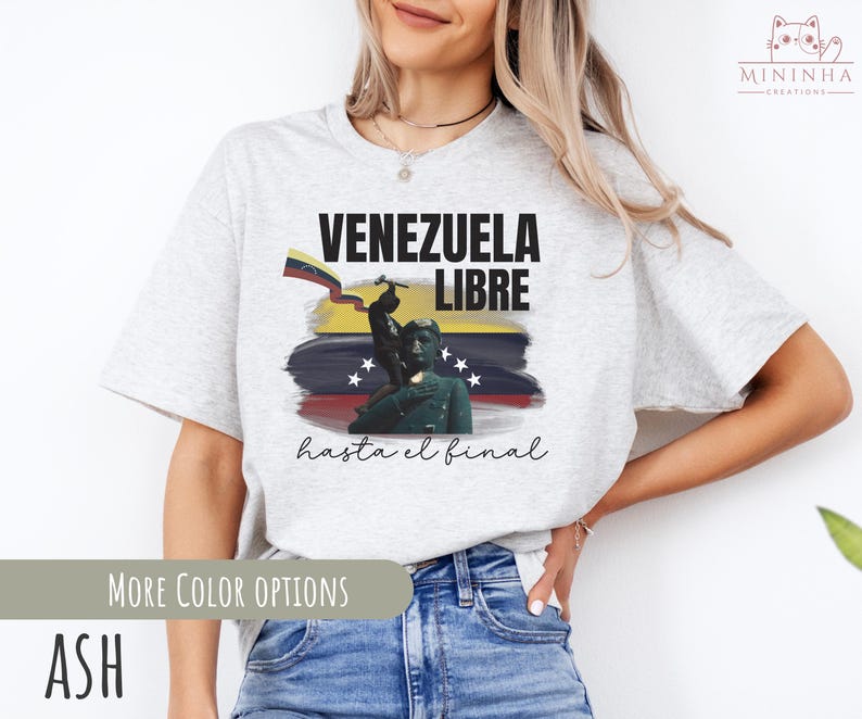May include: A gray t-shirt with a graphic design featuring a Venezuelan flag, a soldier, and the text "Venezuela Libre hasta el final".