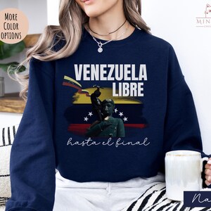 May include: Navy blue sweatshirt with a graphic of a Venezuelan flag and the text "Venezuela Libre hasta el final".