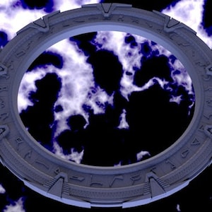 May include: A large, circular, gray metal ring with symbols inscribed around the edge. The ring is set against a dark background with white and blue swirling patterns.