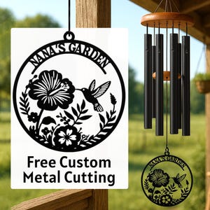 May include: A black metal garden sign and wind chimes. The sign features a floral and hummingbird design with the text "NANA'S GARDEN" and "Free Custom Metal Cutting". The wind chimes have black tubes and a wooden top.