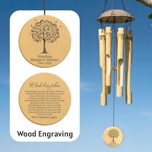 May include: Wooden wind chimes with a natural finish. The chimes feature bamboo tubes and a coconut shell top. The design includes engraved wooden discs with a tree of life and memorial text. The text reads "Grandma Margaret Eleanor 1943-2025" and "A limb has fallen".