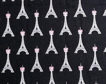 May include: Black fabric with a repeating pattern of white Eiffel Towers with pink bows.