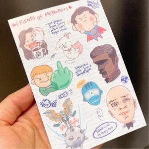 May include: A hand-held notepad with cartoon illustrations of characters from Metropolis. The notepad features drawings of Superman, Lois Lane, and other characters, along with handwritten notes and the text "FRIENDS OF METROPOLIS."