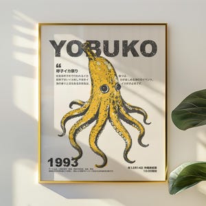 Puede incluir: Un póster enmarcado con borde dorado presenta una ilustración de pulpo amarillo. La palabra "YOBUKO" está en la parte superior, con texto japonés y el año "1993" en la parte inferior. El póster se muestra en una pared blanca.
