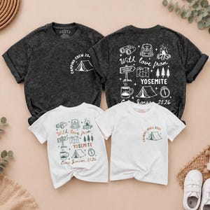 May include: Two charcoal grey and two white t-shirts featuring camping-themed graphics. The shirts display icons of binoculars, backpacks, campfires, maps, trees, tents, and mugs with the text "With love from YOSEMITE" and "CAMPING CREW 2026".