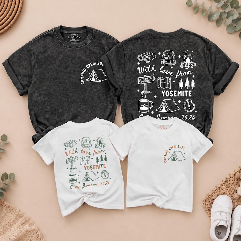 May include: Two charcoal grey and two white t-shirts featuring camping-themed graphics. The shirts display icons of binoculars, backpacks, campfires, maps, trees, tents, and mugs with the text "With love from YOSEMITE" and "CAMPING CREW 2026".