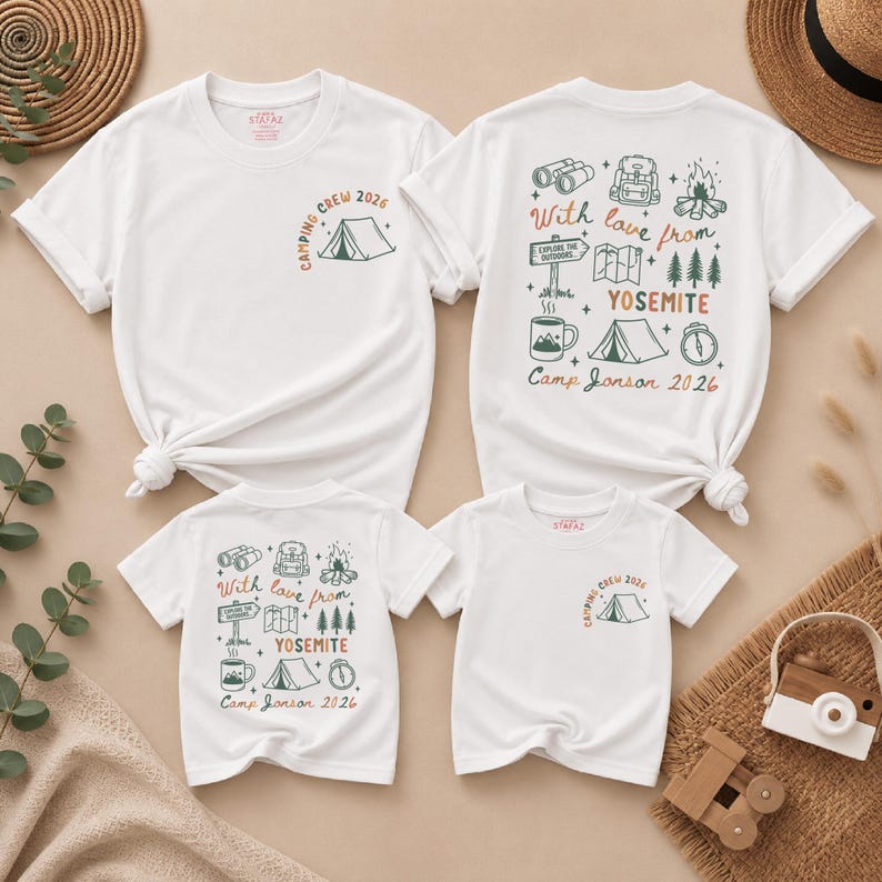 May include: Two white t-shirts with short sleeves. The front features a small tent graphic and the text "CAMPING CREW 2026". The back displays camping icons including binoculars, a backpack, a campfire, a map, trees, a mug, and a tent with the text "With love from YOSEMITE Camp Janson 2026".