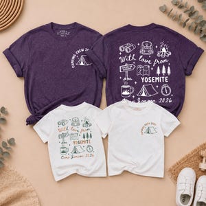May include: Two dark purple and two white t-shirts featuring camping-themed graphics. The front designs show a tent and the text "Camping Crew 2026." The back designs feature illustrations of binoculars, a backpack, a campfire, a map, trees, a mug, a tent, and a compass with the text "With love from YOSEMITE" and "Camp Jonson 2026."
