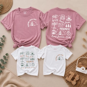 May include: Two mauve and two white short-sleeve t-shirts featuring camping-themed graphics. The front displays a tent and "CAMPING CREW 2026" text. The back features illustrations of binoculars, a backpack, a campfire, trees, and "With love from YOSEMITE Camp Jonson 2026".
