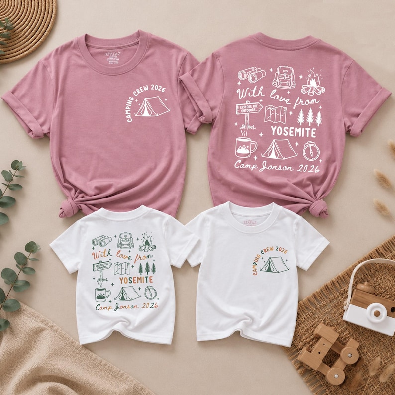 May include: Two mauve and two white short-sleeve t-shirts featuring camping-themed graphics. The front displays a tent and "CAMPING CREW 2026" text. The back features illustrations of binoculars, a backpack, a campfire, trees, and "With love from YOSEMITE Camp Jonson 2026".