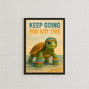 May include: A framed print featuring a cartoon turtle wearing a blue and orange headband and matching armbands. The turtle is walking on a beach with the ocean in the background. The print has the text "KEEP GOING YOU GOT THIS" in blue and orange.