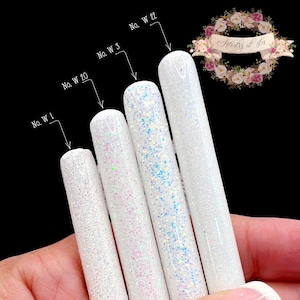 May include: Five white glitter tubes with different sized glitter particles. The tubes are labeled with the numbers 1, 3, 20, and 22.