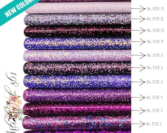 Puede incluir: Un conjunto de 17 palitos de manualidades de purpurina morada, numerados del 1 al 17. Los palitos están dispuestos verticalmente, con los números aumentando de abajo hacia arriba. El texto "NEW COLORS ADDED!" está en la esquina superior izquierda de la imagen.