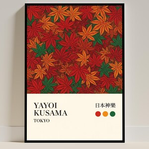 Può includere: Una stampa artistica incorniciata con un motivo ripetuto di foglie d'acero rosse, arancioni e verdi. La stampa include il testo "YAYOI KUSAMA TOKYO" e caratteri giapponesi. L'opera d'arte ha una cornice nera e uno sfondo color crema.