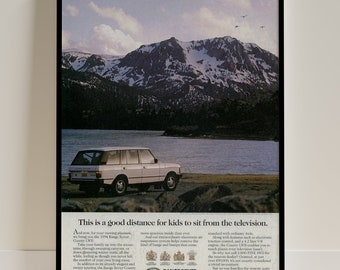 May include: A white Range Rover SUV is parked on a rocky shore in front of a lake and snow-capped mountains. The text "This is a good distance for kids to sit from the television." is at the bottom of the image. The Range Rover logo is at the bottom right corner of the image.