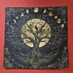 Könnte beinhalten: Ein quadratisches, schwarzes Wandtuch mit einem Baum vor einem Vollmond und Mondphasen. Ein schwarzer Vogel sitzt auf einem Ast. Die Wurzeln und Äste des Baumes sind aufwendig mit einem himmlischen Design detailliert. Das Wandtuch hängt an einer roten Wand.