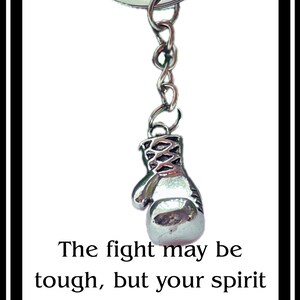 May include: Silver boxing glove keychain with a round key ring and chain. The text on the image reads: "The fight may be tough, but your spirit is tougher. I'm always in your corner."