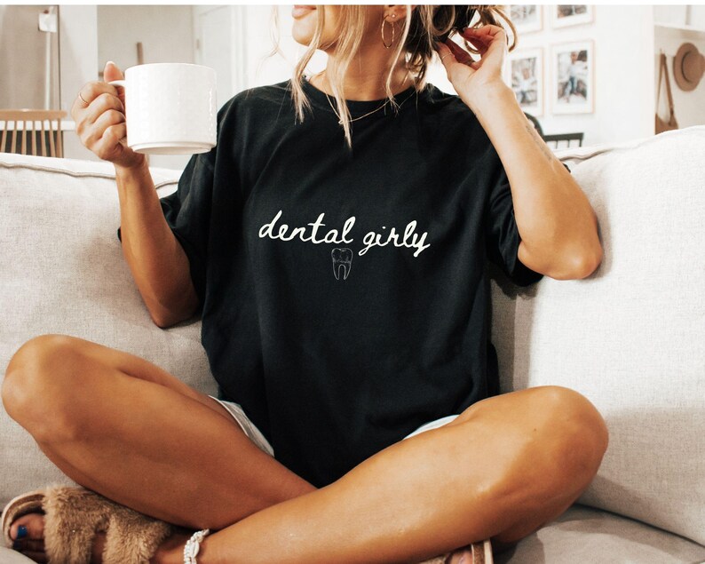 May include: A black t-shirt with the text "dental girly" and a small white tooth graphic.