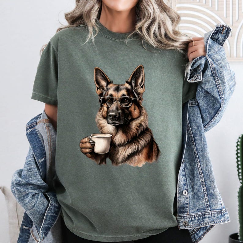 Puede incluir: Una camiseta verde con una imagen de dibujos animados de un perro pastor alem&aacute;n con gafas y sosteniendo una taza de caf&eacute;.
