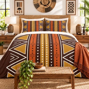 May include: A bedding set featuring a duvet cover and two pillow shams with a geometric pattern in shades of brown, orange, and mustard yellow. The design includes vertical stripes, triangles, and circular motifs on a white background.