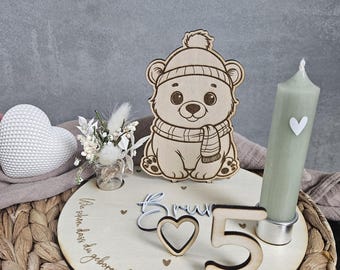 Peut inclure: Décoration d'anniversaire en bois avec un ours portant un chapeau et une écharpe, une bougie et les mots "Nous sommes si heureux que tu sois né !" et "Brun 5".