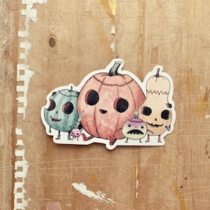 May include: A set of four Halloween-themed vegetable characters. A pink pumpkin with a stitched mouth and black eyes, a green gourd with a toothy grin, a purple turnip with a mustache, and a tan squash with a skull-like face.