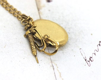 syringe locket necklace. in gold ox oval locket