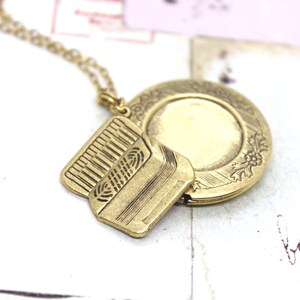 accordion. round locket necklace. in gold ox with floral locket jewelry