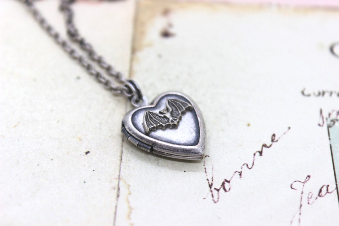 bat. heart locket necklace. silver ox jewelry with a silver tone bat or a silver ox bat