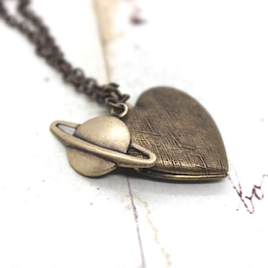 planet. heart locket necklace. in brass ox with Saturn