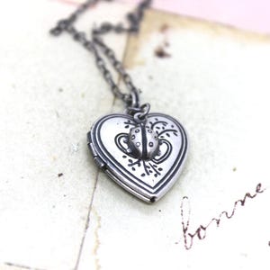 ladybug. locket necklace. silver ox with double heart pattern