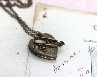 biplane. heart locket necklace. in brass ox with etched lines pattern