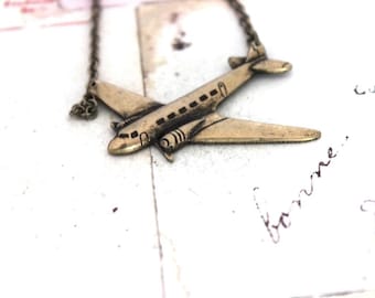 airplane. necklace. brass ox