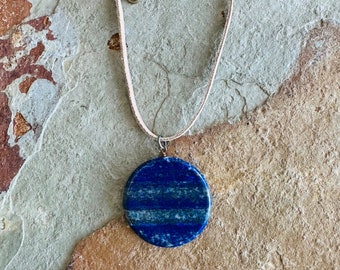 Large lapis lazuli circle pendant on a leather cord
