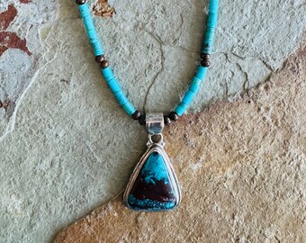 Boulder turquoise and sterling silver pendant on a turquoise and bronzite necklace