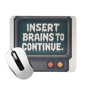 May include: A white computer mouse next to a rectangular mousepad. The mousepad features a pixelated design of a retro television screen with the text "INSERT BRAINS TO CONTINUE."