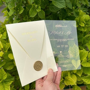 Elegante acryl uitnodigingsset met speciale enveloppen en gepersonaliseerde zegellak, transparante bloemenkaart met goudprint.