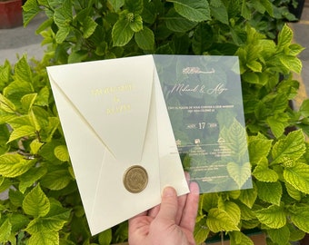 Elegantes Acryleinladungsset mit speziellen Umschlägen und personalisiertem Siegelwachs, transparente Blumenkarte mit Golddruck.