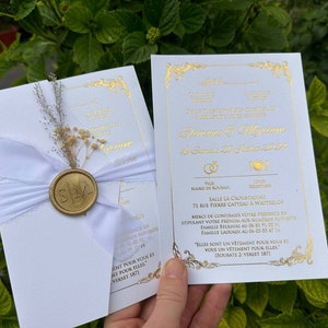 White paper invitation set with gold print and dried flowers
