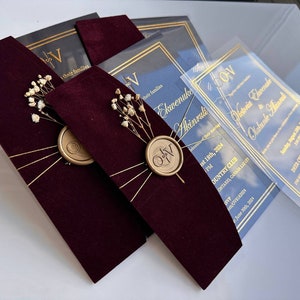 Fluwelen uitnodigingsset; Bordeauxkleurige enveloppen met heldere acrylkaart met goudprint en gepersonaliseerde zegelwas met droogbloemen.