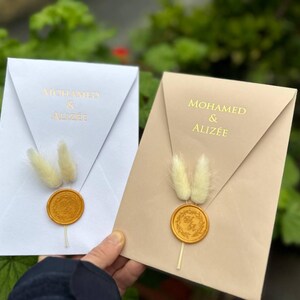 Cremefarbenes Hochzeitseinladungs-Set mit goldenem Druck und Blumen; Transparente Hochzeitseinladungen mit natürlichen Blumen und benutzerdefinierten Siegelwachs