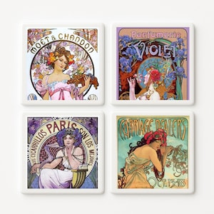 May include: Four square ceramic coasters featuring Art Nouveau designs. Each coaster showcases a different vintage advertisement with elegant women, floral motifs, and text. The coasters have a white border and are ideal for home decor.